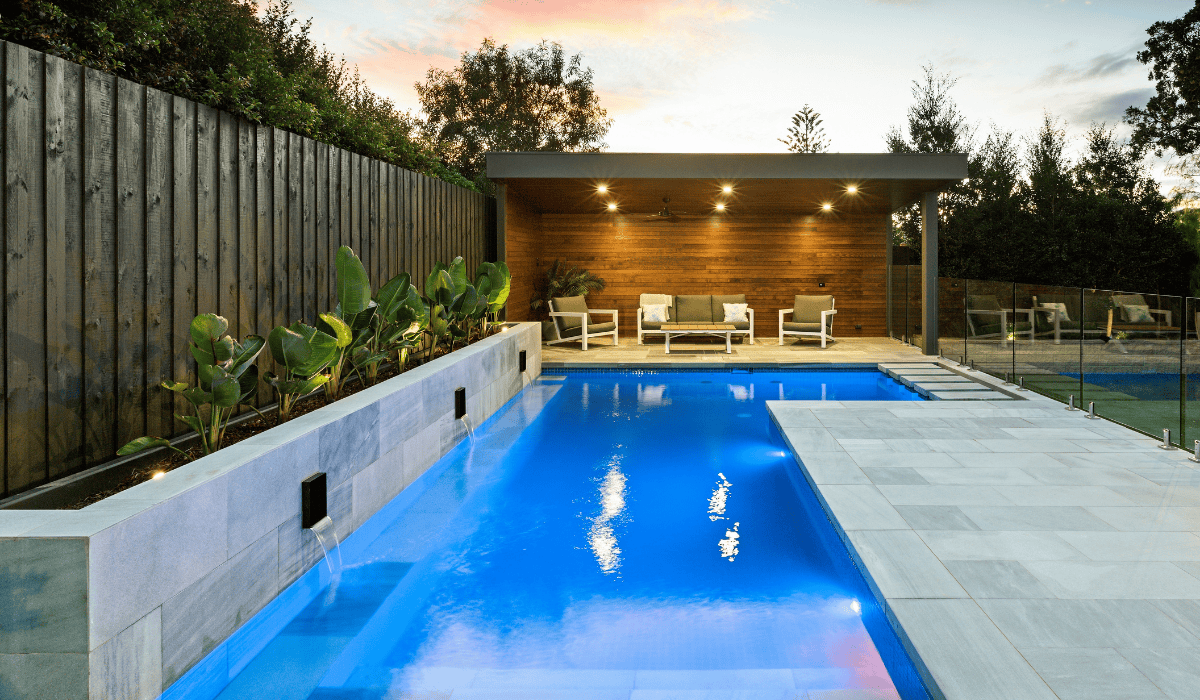 Modern backyard pool with wooden cabana and lush greenery in Eltham.