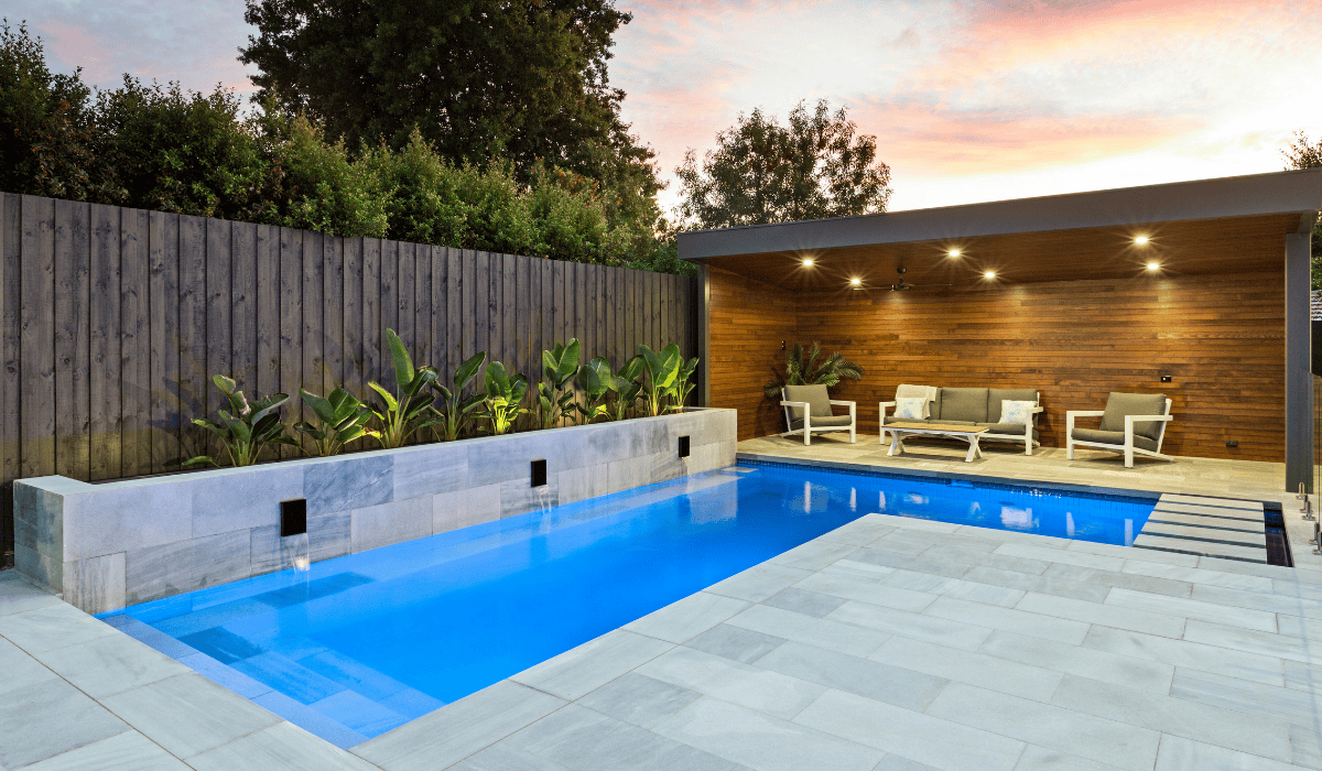 Modern backyard pool with wooden cabana and lush greenery in Australia.