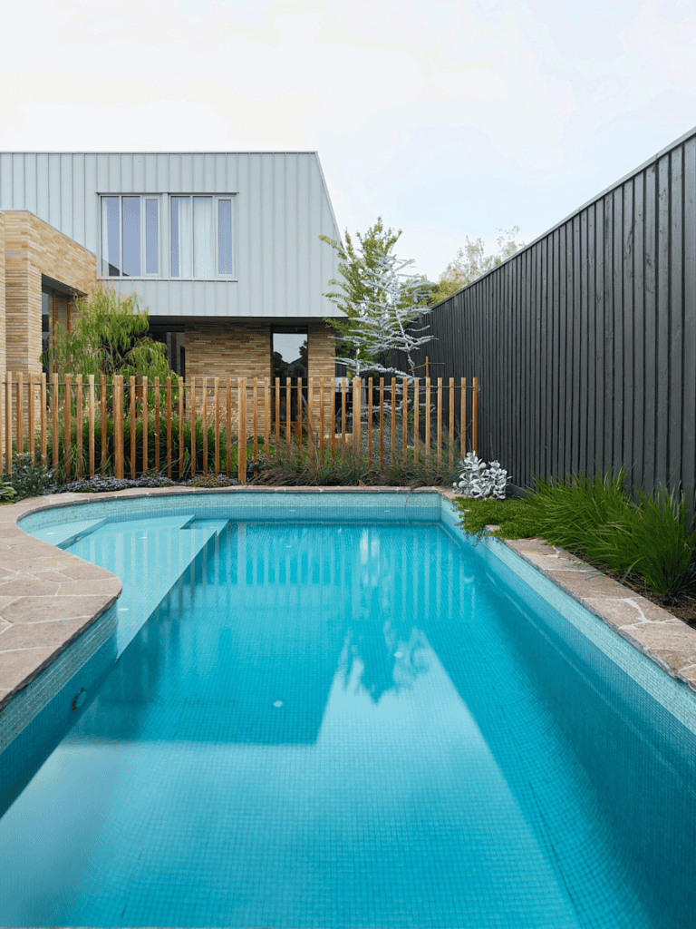 Modern backyard with a sleek swimming pool and contemporary house design.