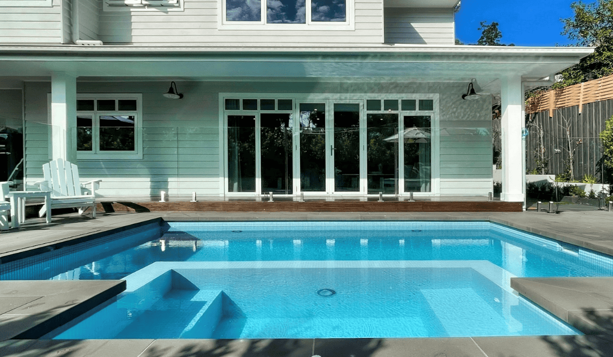 Modern backyard with custom in-ground swimming pool and outdoor seating area.