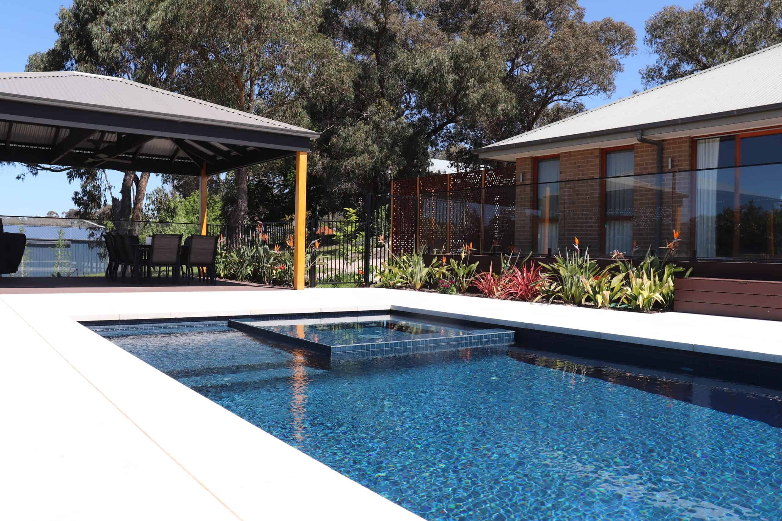 Modern backyard pool with surrounding garden and outdoor seating area in Plenty 3.