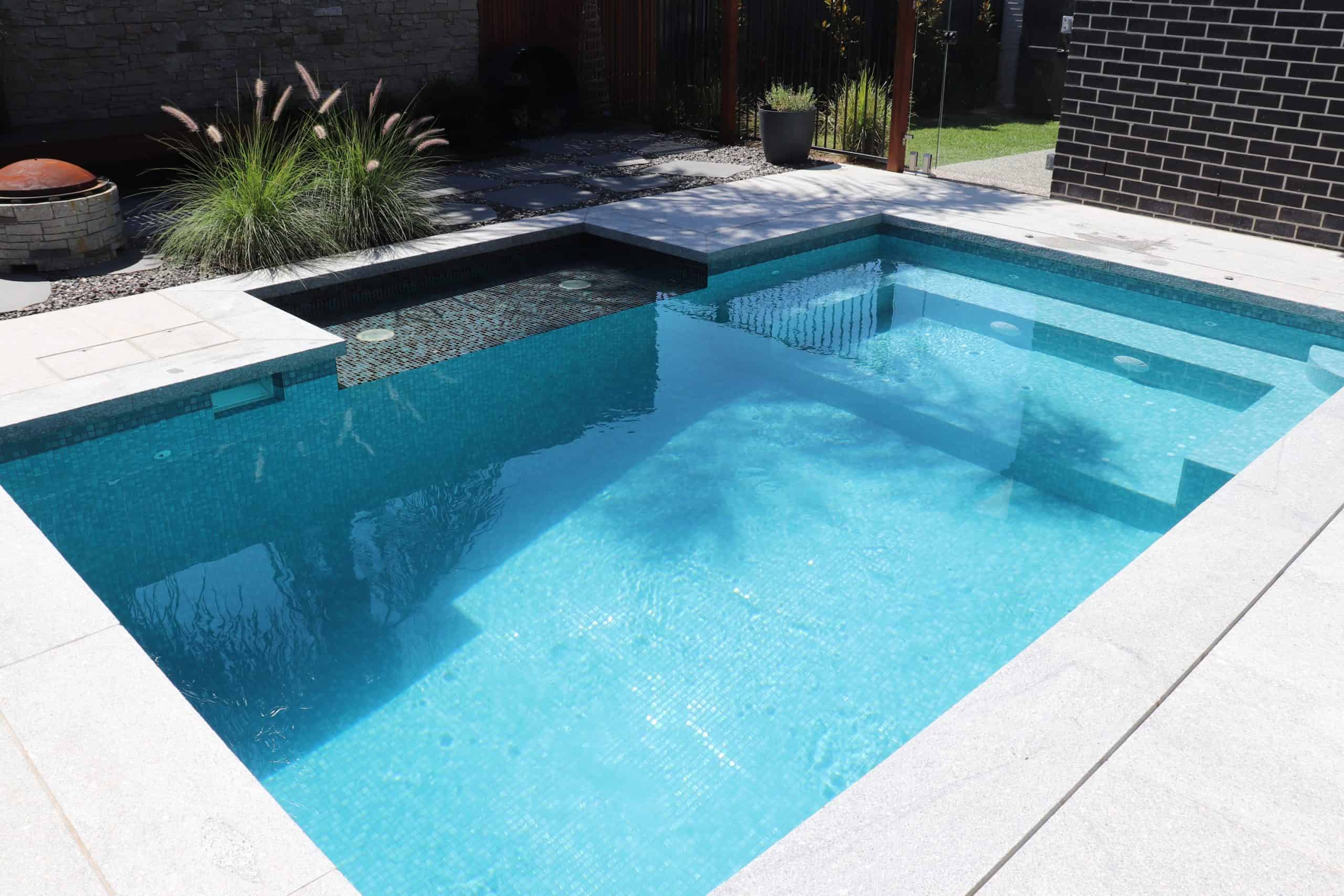 Modern in-ground swimming pool with steps and surrounding patio in South Morang.