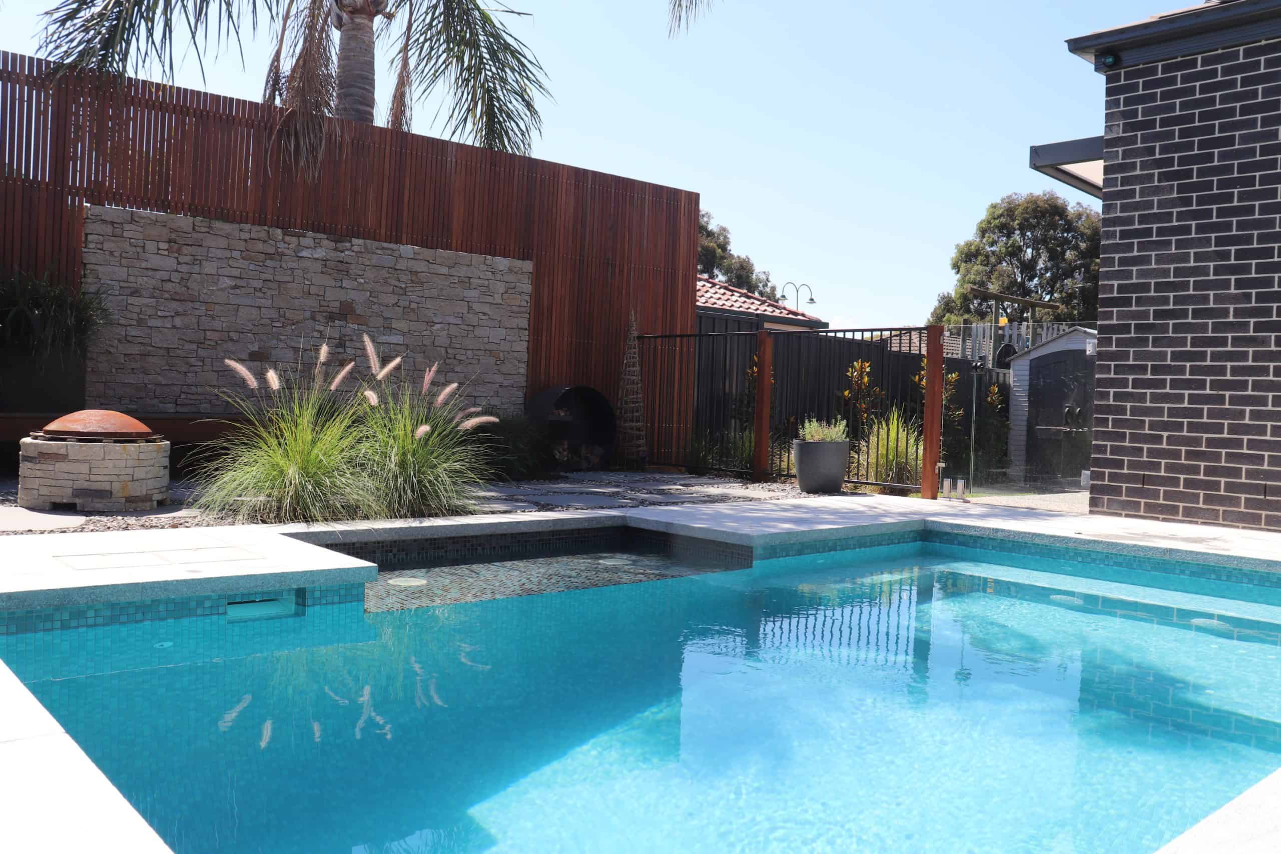 Modern backyard pool with waterfall feature and landscaped garden in South Morang.